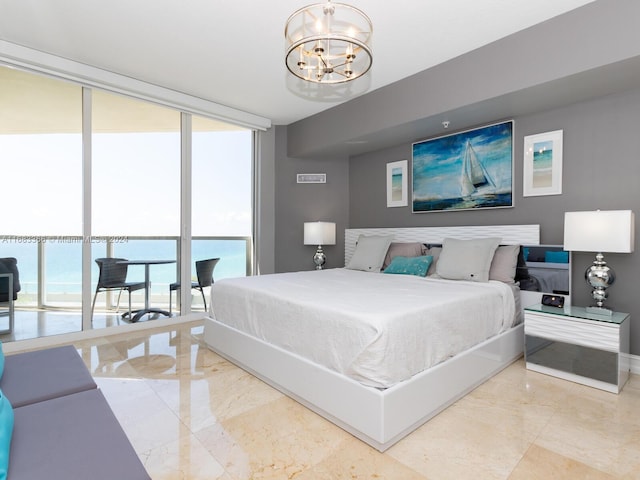 bedroom featuring a notable chandelier and a water view