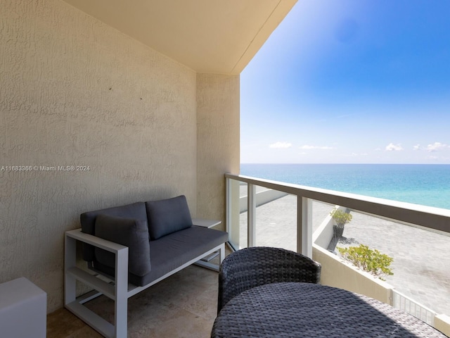 balcony with a water view and a view of the beach