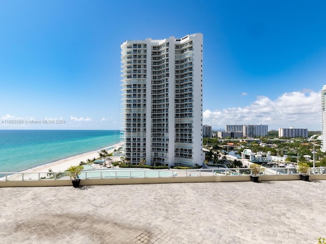 view of building exterior featuring a beach view and a water view