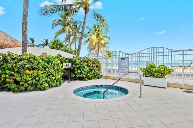 view of pool featuring a water view and a hot tub