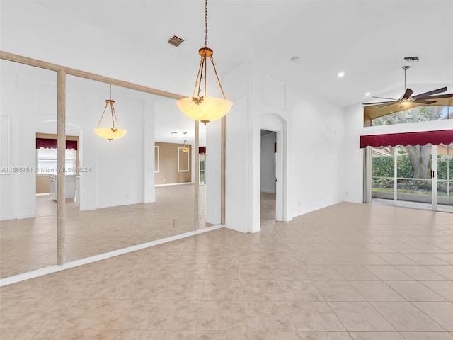 unfurnished living room featuring ceiling fan, arched walkways, a high ceiling, light tile patterned floors, and recessed lighting