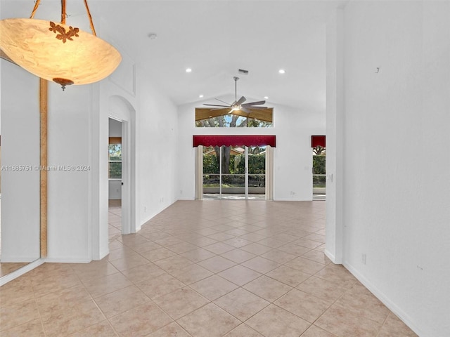 empty room with healthy amount of natural light, arched walkways, light tile patterned floors, a ceiling fan, and recessed lighting
