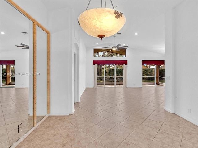 corridor with tile patterned flooring, recessed lighting, arched walkways, and high vaulted ceiling