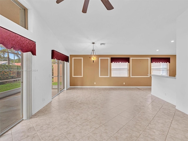 unfurnished room with lofted ceiling, light tile patterned flooring, and ceiling fan with notable chandelier