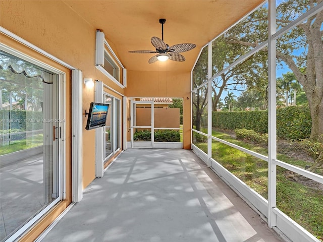 unfurnished sunroom featuring ceiling fan and plenty of natural light