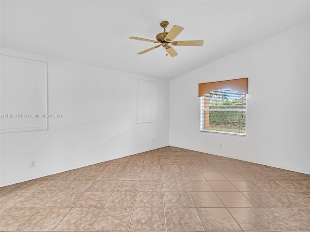 empty room featuring ceiling fan, lofted ceiling, and light tile patterned floors