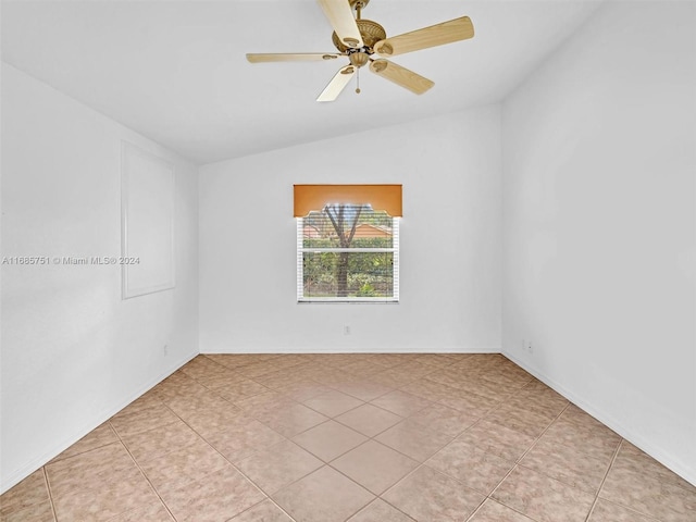 spare room featuring ceiling fan, vaulted ceiling, and light tile patterned floors