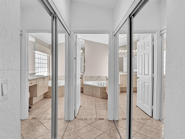 hallway featuring light tile patterned floors and sink