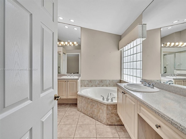 bathroom featuring tile patterned flooring, a bath, two vanities, a stall shower, and recessed lighting