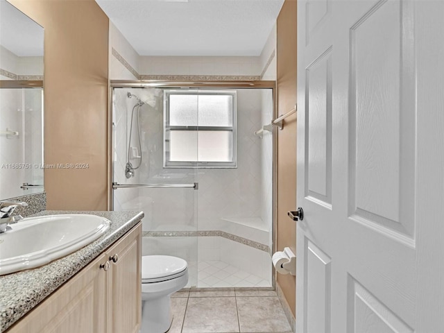bathroom with toilet, a stall shower, vanity, and tile patterned flooring