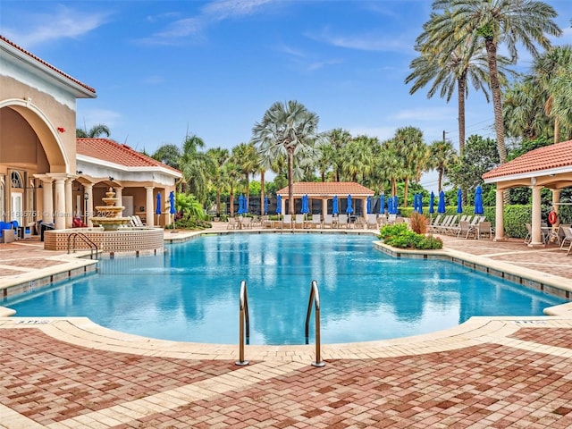community pool with a gazebo and a patio area