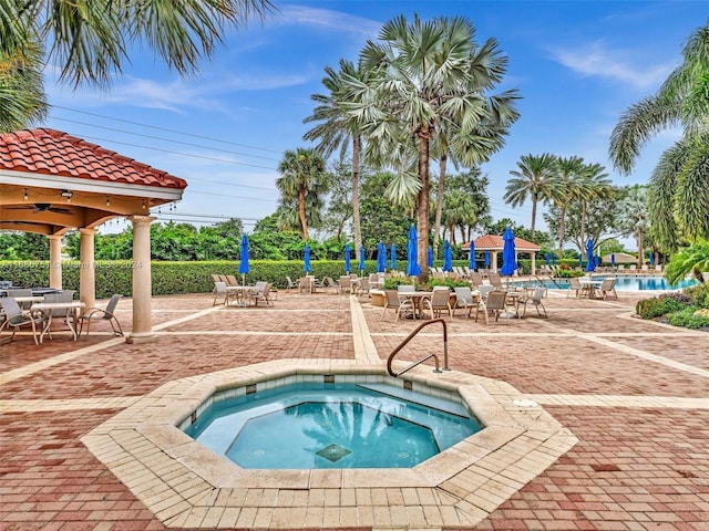 community pool featuring a gazebo, a hot tub, and a patio area