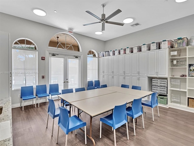 dining space featuring french doors, light wood-type flooring, and ceiling fan