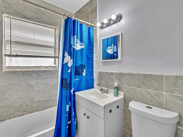 full bathroom with vanity, toilet, tile walls, and shower / bath combo with shower curtain