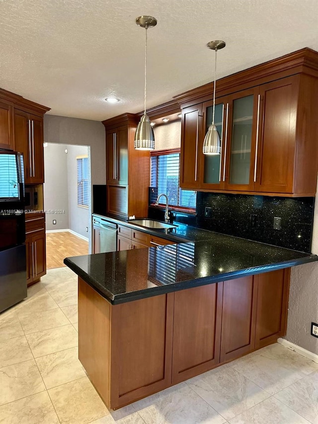 kitchen with pendant lighting, tasteful backsplash, sink, and kitchen peninsula