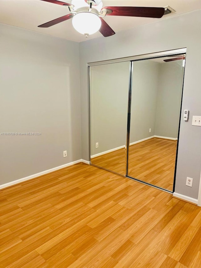 unfurnished bedroom featuring a closet, ceiling fan, and hardwood / wood-style flooring