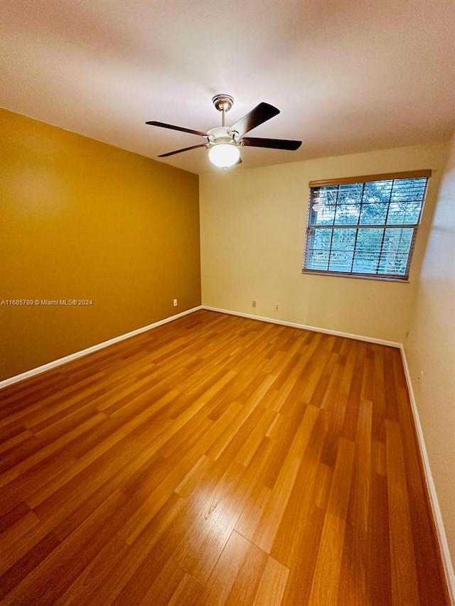 spare room featuring wood-type flooring and ceiling fan