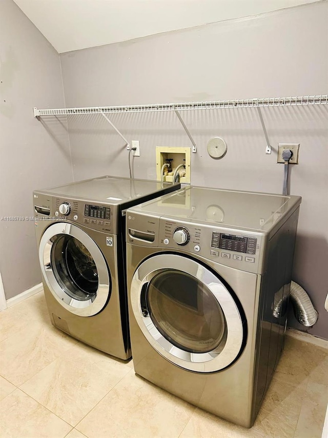 laundry room with light tile patterned floors and separate washer and dryer