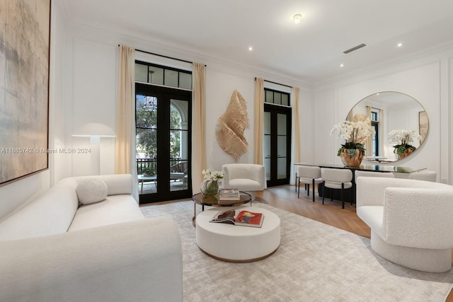 living room with ornamental molding, french doors, and light hardwood / wood-style floors