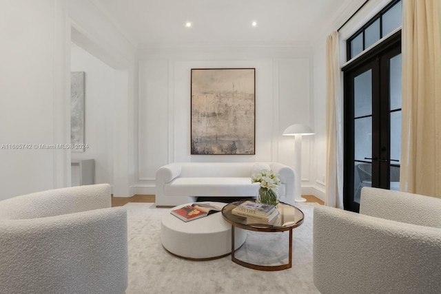 living room featuring french doors, ornamental molding, and hardwood / wood-style floors