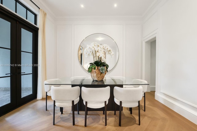 dining area with french doors, crown molding, and light parquet floors