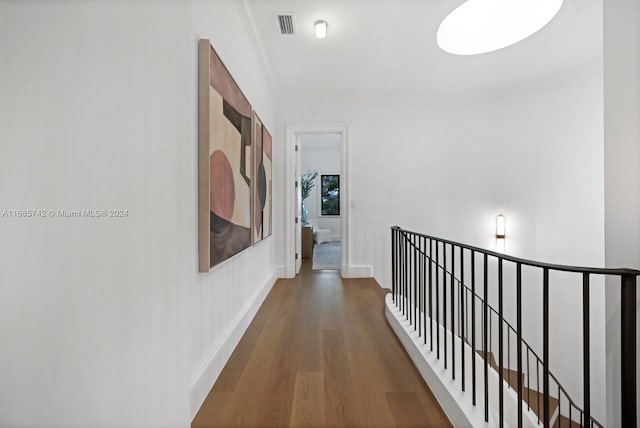 hall with ornamental molding and wood-type flooring