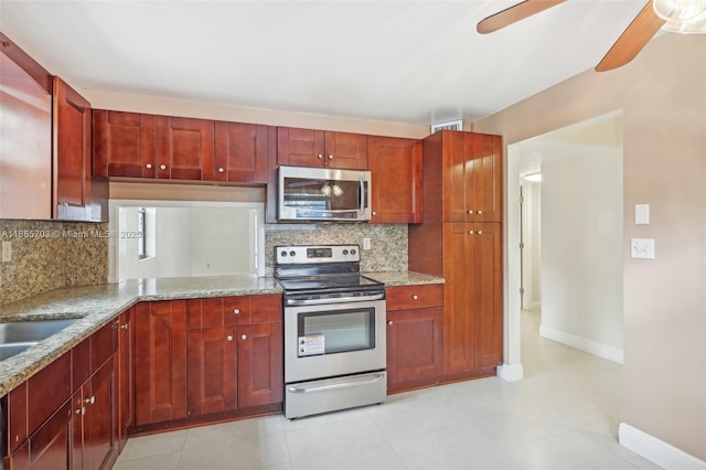 kitchen featuring appliances with stainless steel finishes, decorative backsplash, ceiling fan, light tile patterned flooring, and light stone counters