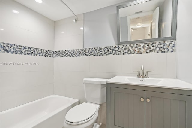 full bathroom featuring vanity, toilet, tile walls, and bathing tub / shower combination