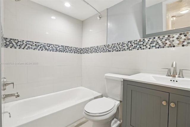 full bathroom with vanity, washtub / shower combination, tile walls, and toilet