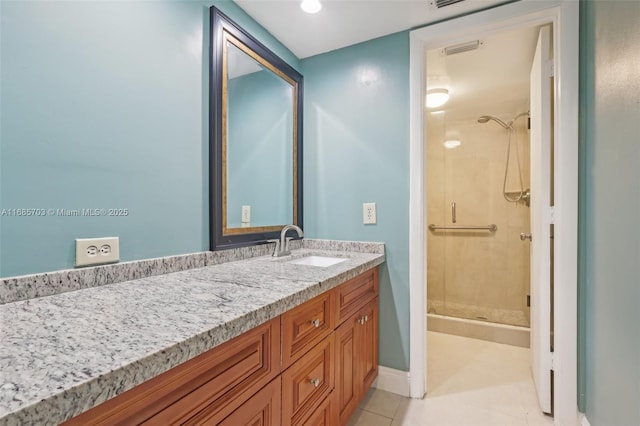 bathroom featuring tiled shower, tile patterned flooring, and vanity