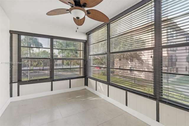 unfurnished sunroom featuring ceiling fan