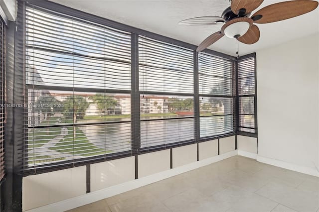 unfurnished sunroom featuring ceiling fan