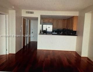 kitchen with white fridge and dark wood-type flooring