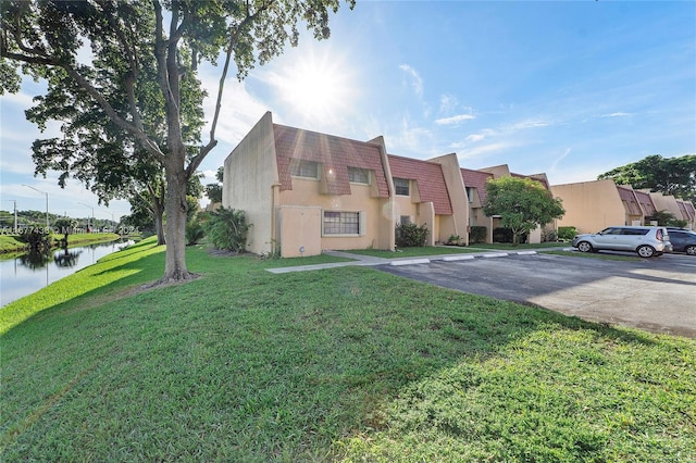 view of front of property with a front yard and a water view