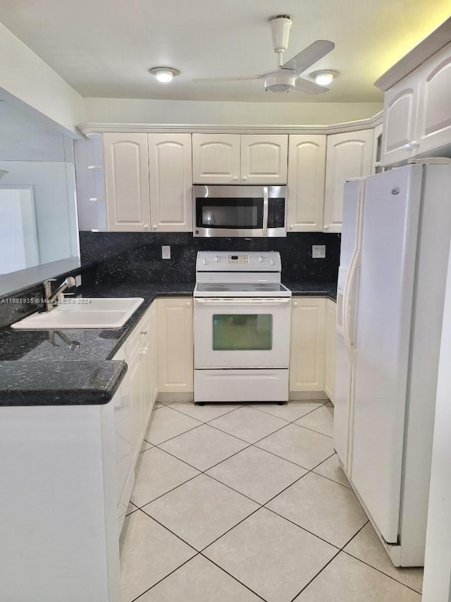 kitchen featuring light tile patterned floors, backsplash, dark stone counters, sink, and white appliances