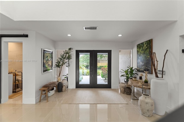 foyer entrance featuring a barn door and french doors