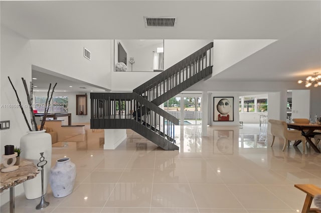 staircase featuring a chandelier and tile patterned flooring