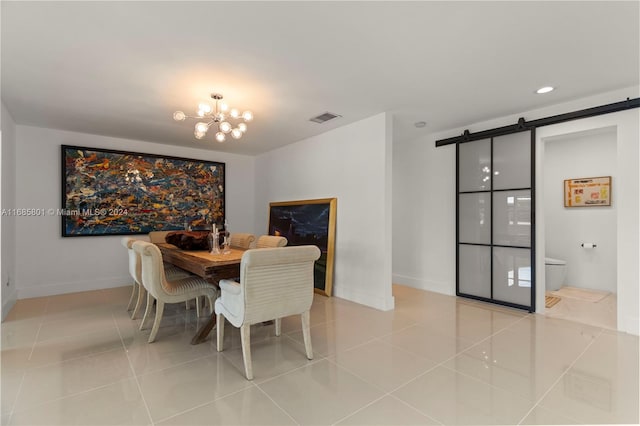 tiled dining room featuring a notable chandelier and a barn door