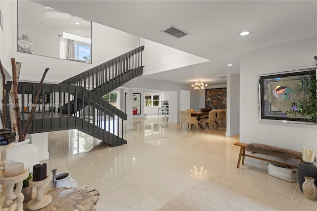 staircase featuring tile patterned floors and a notable chandelier