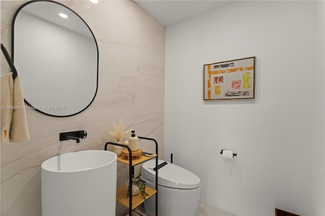 bathroom with tile walls and toilet