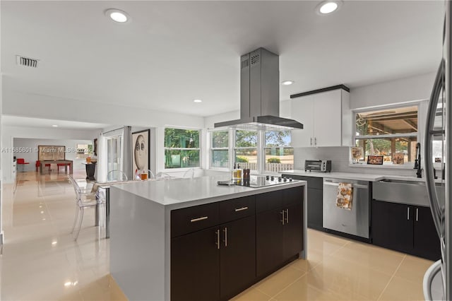 kitchen with island range hood, white cabinets, stainless steel dishwasher, a kitchen island, and light tile patterned flooring