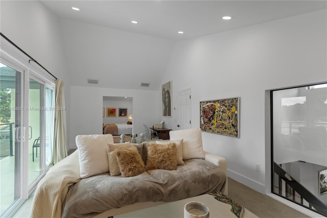 carpeted living room featuring high vaulted ceiling