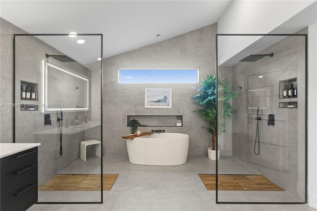 bathroom featuring shower with separate bathtub, lofted ceiling, tile walls, tile patterned flooring, and vanity