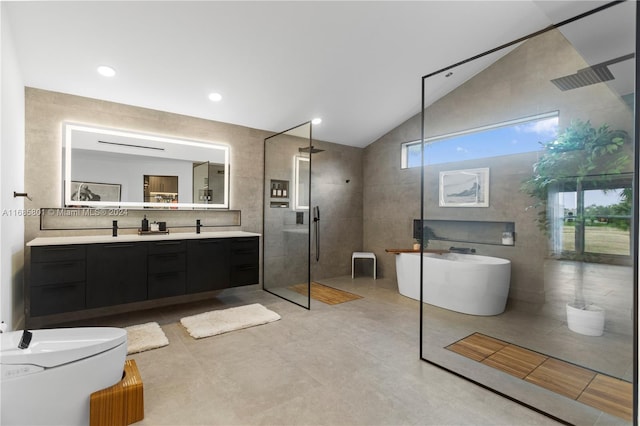 bathroom with tile walls, shower with separate bathtub, vaulted ceiling, and vanity