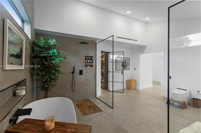 bathroom featuring shower with separate bathtub and toilet