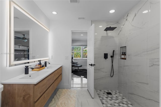 bathroom with ceiling fan, vanity, and tiled shower