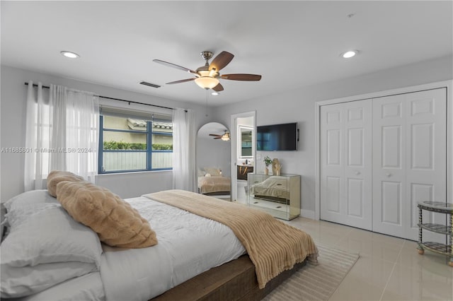 bedroom featuring light tile patterned floors, ceiling fan, and a closet