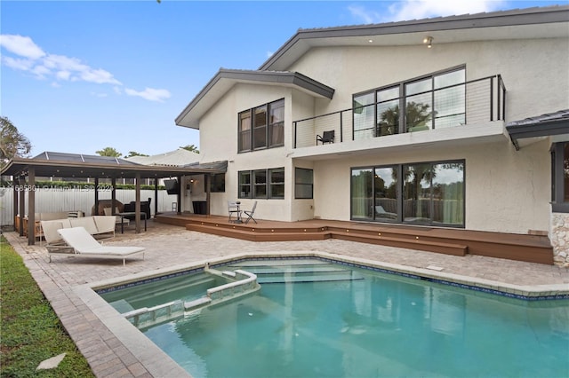 back of property featuring a fenced in pool and a patio area