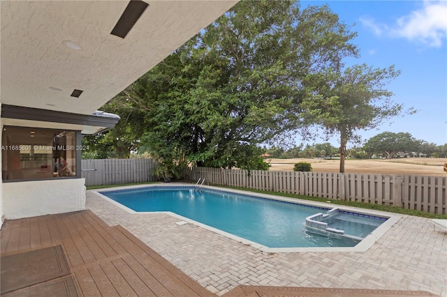 view of swimming pool featuring a patio area and an in ground hot tub