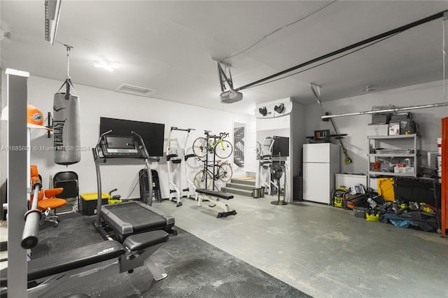 garage with a garage door opener and white refrigerator